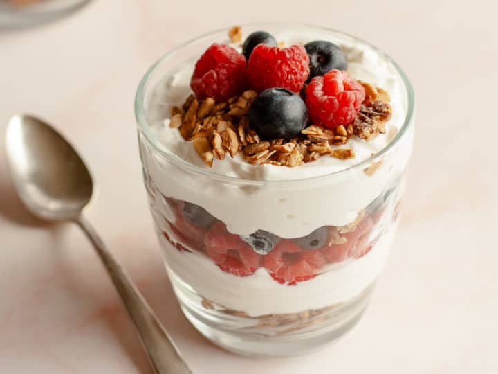 Breakfast Parfait with berries and granola sitting with elegant spoon