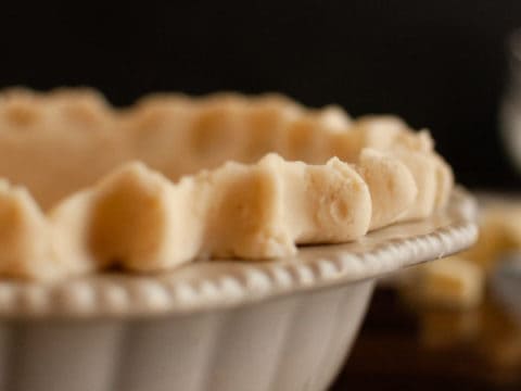 Flaky Gluten Free Pie crust in ceramic pie dish with dark background