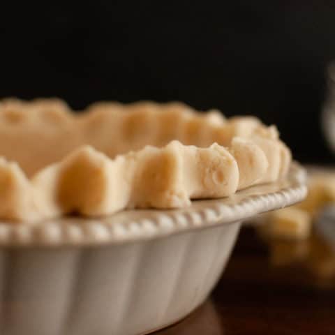 Flaky Gluten Free Pie crust in ceramic pie dish with dark background