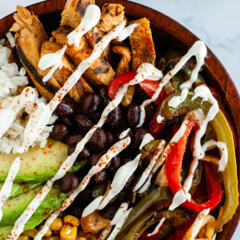 Grilled Fajita Bowl on marble surface surrounded by lime slices