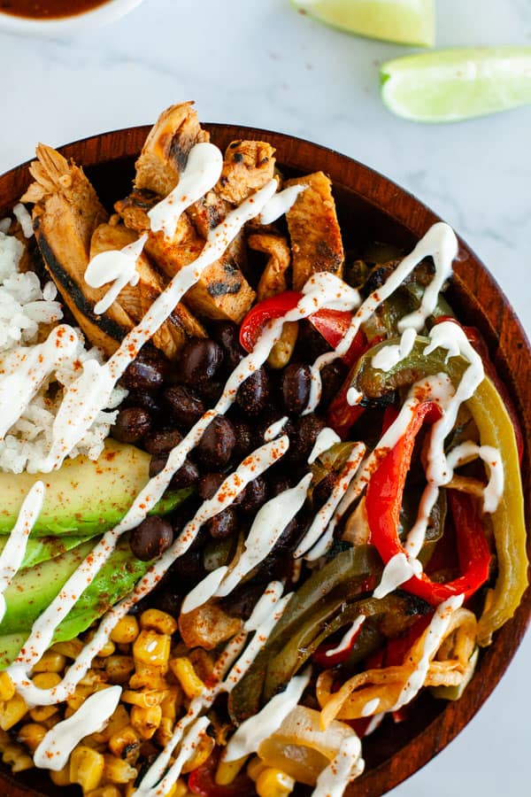 Grilled Fajita Bowl on marble surface surrounded by lime slices