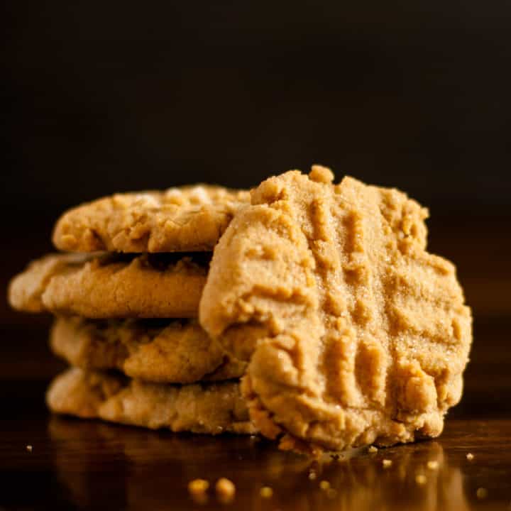 Easy Gluten Free Peanut Butter Cookies stacked with crumbs surrounding