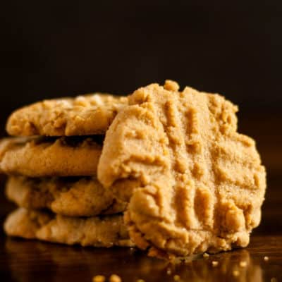 Gluten Free Peanut Butter Cookies in a stack with featured cookie leaning along side