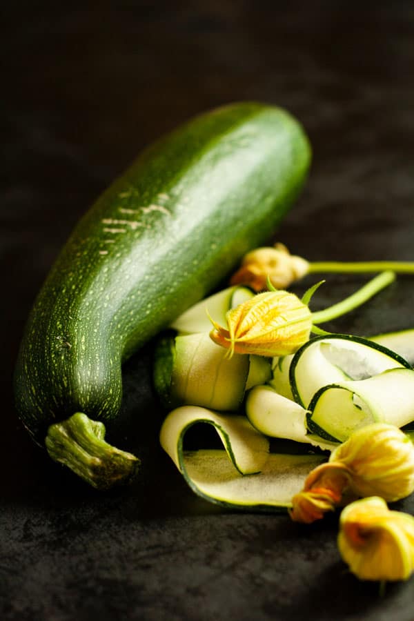 Welcoming Autumn, Zucchini in sunlight surrounded by produce blossoms