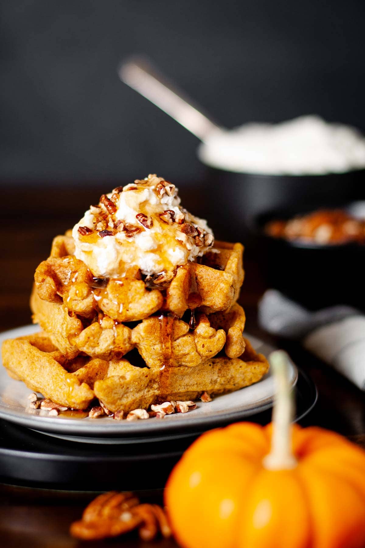 Buttermilk Pumpkin Waffles served with whipped cream and pecan pieces