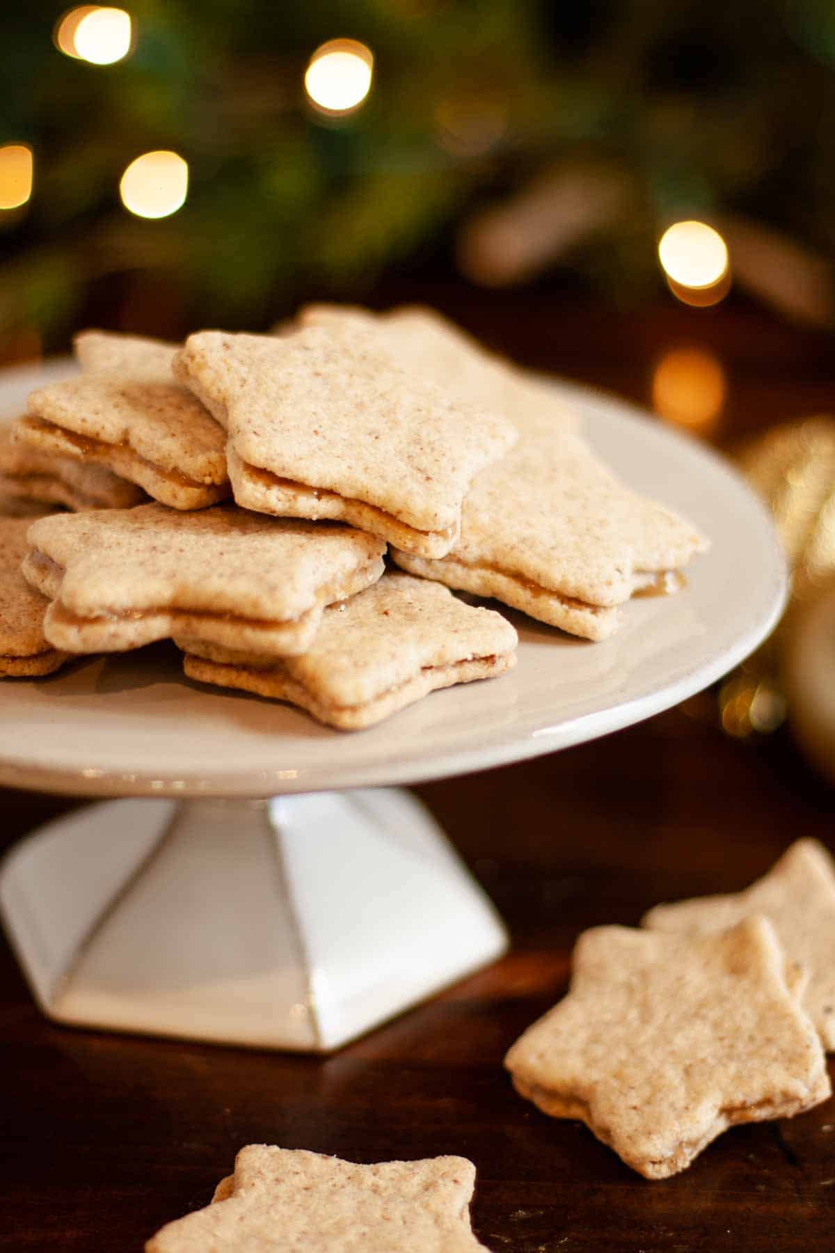 Gluten Free Pecan Shortbread Cookies finished and filled with caramel filling on display surrounded by holiday lights