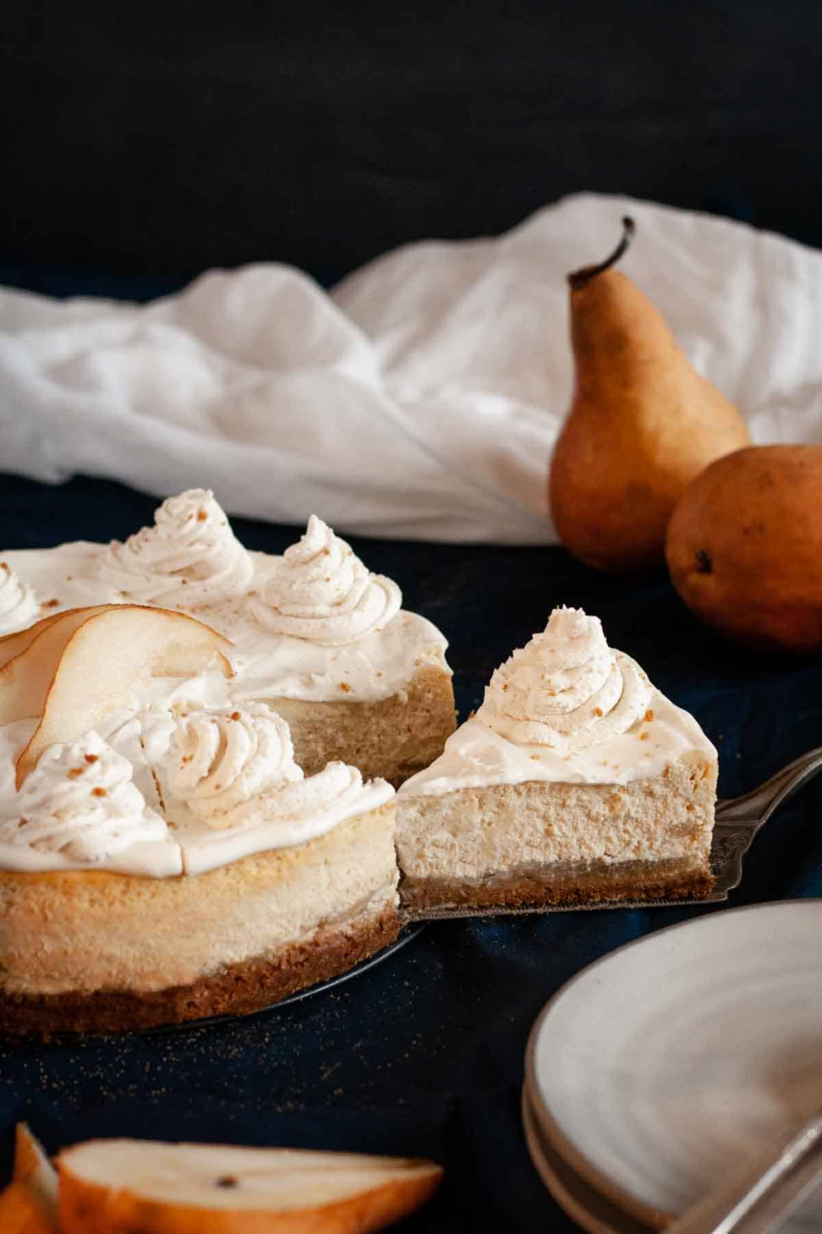 finished image of pear cheesecake with a slice of cheesecake being cut.