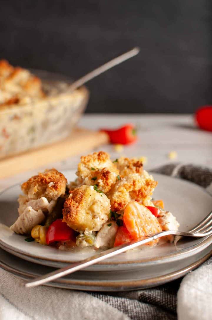a serving of grandma's chicken and biscuit casserole on ceramic plate with fork