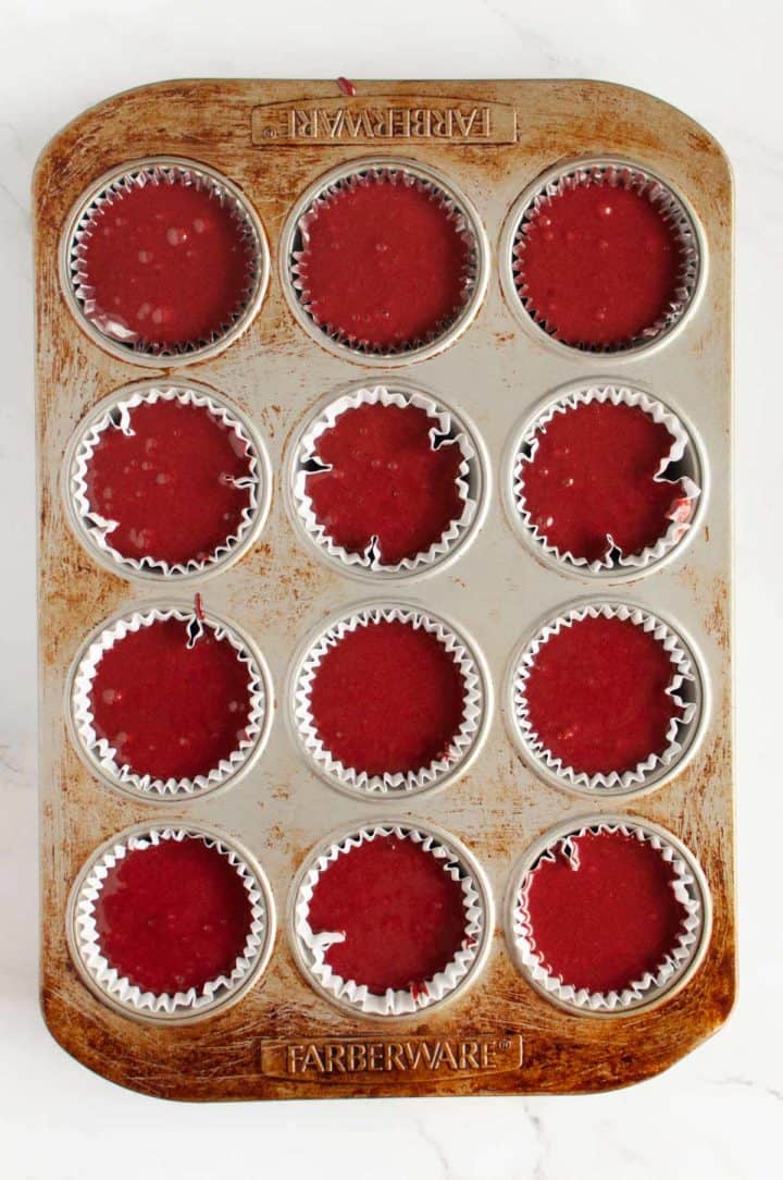 batter for red velvet cupcakes portioned into muffin tin ready for oven