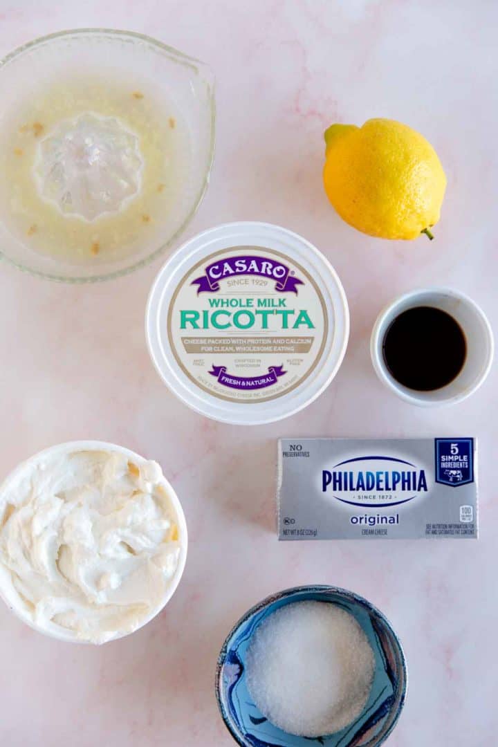 ingredients needed for ricotta filled crepes, displayed on a pink marble surface