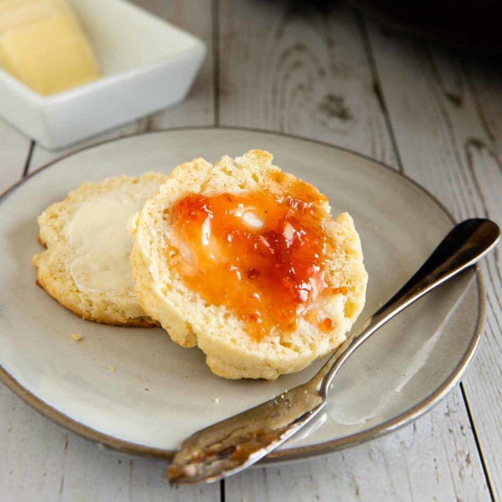 gluten free biscuit on plate with a spread of butter and jelly