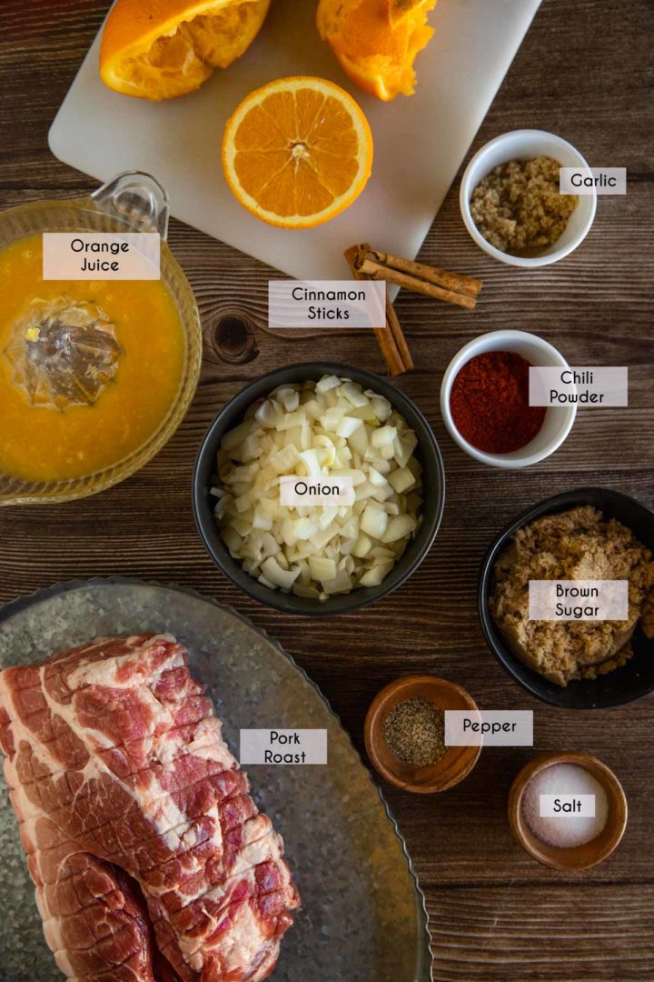 Ingredients needed for homemade pulled pork laid out and displayed on a wooden surface