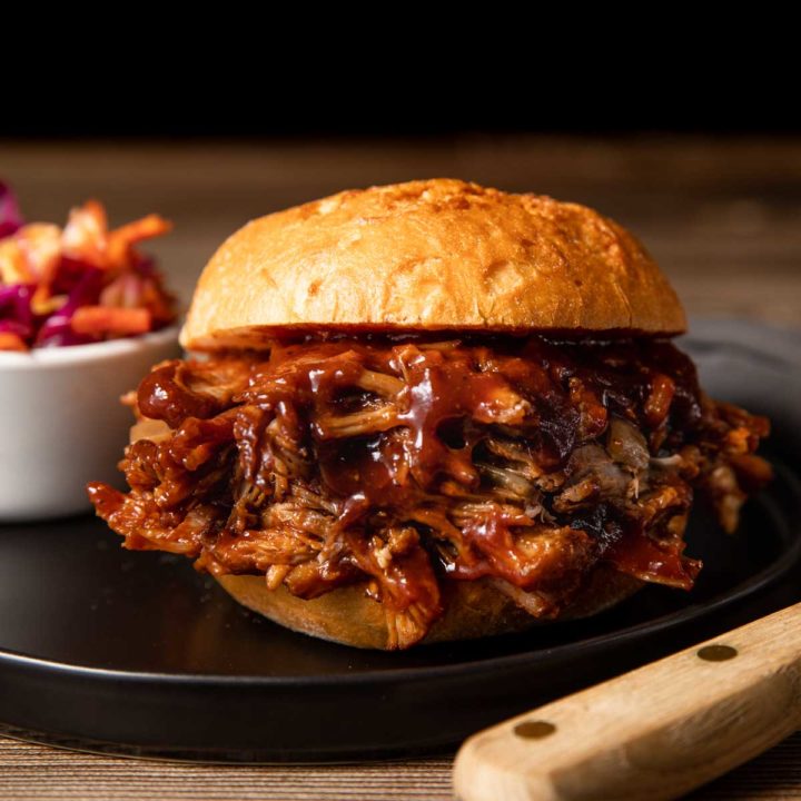 homemade pulled pork with a side of coleslaw and homemade barbecue sauce