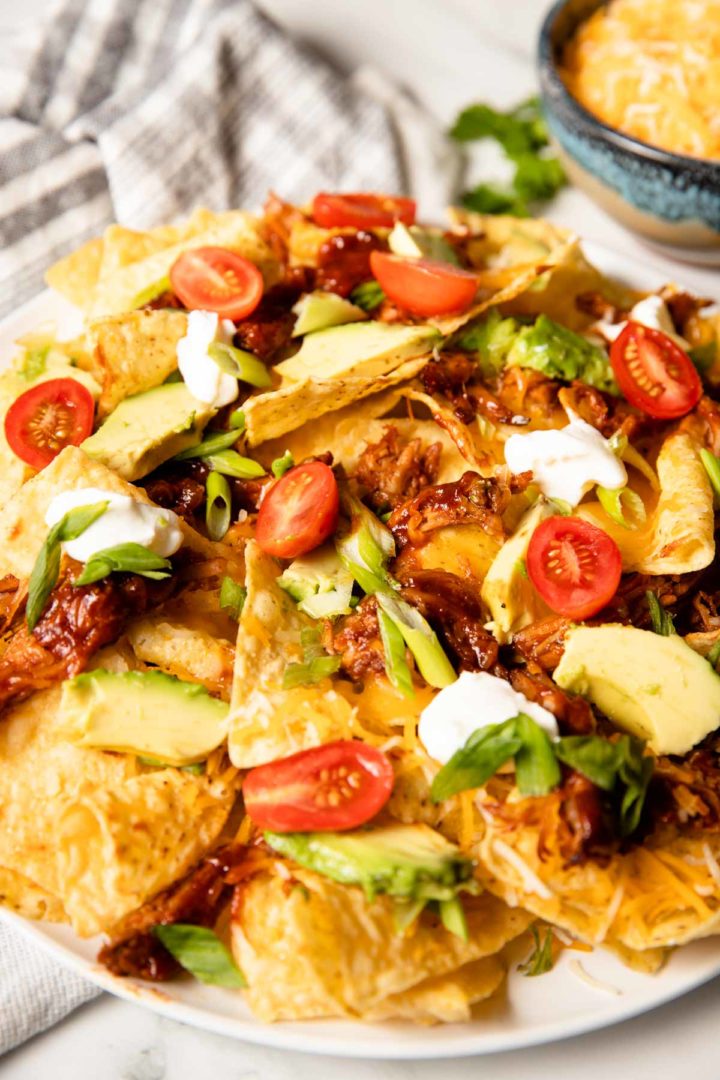 easy shredded pork nachos served on a white plate with toppings